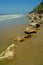 Waves, beach, fence, rocks, and hillside