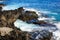 Waves beat against stones of volcanic origin on the island of San Miguel, Azores. Seascape. Travel