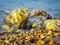 Waves are beating against the rocks on the beach of the sea beach in the summer time at sunny weather.