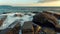 Waves break on coastal stones