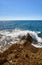 Waves breaking against the rocks in the seashore at the Sierra de Irta national park in Castellon, Spain, on a sunny day in summer