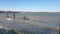 Waves breaking on an old ruined wooden structure at high tide on a sunny spring day with a bright blue sky, River Deben, Suffolk