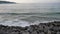 Waves breaking over rocks on the beach.