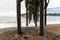 Waves breaking on the poles under the pier of San Simeon, California, USA