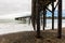 Waves breaking on the poles under the pier of San Simeon, California, USA