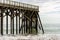 Waves breaking on the poles under the pier of San Simeon, California, USA