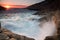 Waves breaking on a rocky seashore at sunset