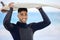 The waves are calling my name. Shot of a young man holding a surfboard at the beach.