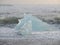 The waves clashing a huge blue iceberg on Black Sand Beach