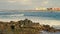 The waves crash against the rocks, the city's coastline.