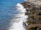 Waves crash on big rocks. Rocky coast and wave. Powerful coastline. Sea foam. The excitement of the sea. Huge coastal rocks