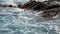 Waves crash on the rocky shore. Beautiful seascape with crystal turquoise sea.