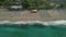 Waves crash on the sandy shore of the beach. Top view of the beach with sun loungers.