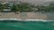 Waves crash on the sandy shore of the beach. Top view of the beach with sun loungers.