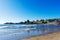 Waves crashing against the shore of Capitola Beach on California Pacific Coast under blue sky