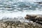 Waves crashing against a stones with foam and splashes. Ocean Rocky beach