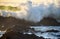 Waves crashing over rocks from the ocean\'s incoming morning tide.