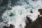 Waves crashing on rocks, Atlantic Ocean. Azure sea waves with white foam breaking on coast. Splash of aquamarine sea water.