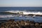 Waves crashing on rocks on Atlantic Ocean beach. Scenic seascape. Beautiful surf at seaside. Splashing waves with foam.
