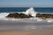 Waves crashing on rocks on Atlantic Ocean beach. Scenic seascape. Beautiful surf at seaside. Splashing waves with foam.