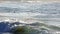 Waves crashing on the Sandy beach with an udidentified people on Oahu, Hawaii