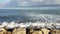 Waves crashing on seawall rocks at a Mediterranean port