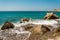 Waves entering Pissouri pebble beach through large rocks in the water, Cyprus