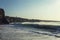 Waves foam at the beach. Mountains. Clear sky