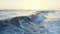 Waves foaming and splashing in the sea. Drone footage, sunset wavy seascape. Sunset over ocean waves, flying over the