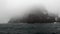 Waves and fog on background of snow rock in ocean of Antarctica.