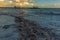 Waves froth together just off the beach in front of the pier at Worthing, Sussex in late afternoon