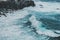 Waves hitting coastling - black cliff on ocean coast -