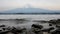 Waves on Lake Kawaguchi shoreline with Mount Fuji in background, Japan.