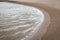 Waves lapping against curved, sandy beach, St Andrews, Scotland