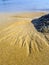 Waves moving sand along the beach