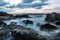 Waves in the ocean at sunset at Koh Lanta with Stones in the sea and Phi Phi islands in the horizon, Koh Lanta, Thailand