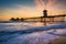 Waves in the Pacific Ocean and the pier at sunset