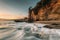 Waves in the Pacific Ocean and the Pirate Tower at sunset, at Victoria Beach, Laguna Beach, California