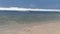 The waves, ripples and sea foam move onto the sand on the beach