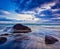 Waves and rocks on beach of sunset