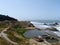 Waves roll towards shore of Ocean Beach with Cliff House and the ruins of the Sutro Bath House in foreground