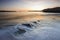 Waves rolling on beach at twilight