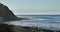 Waves rolling into a rocky shore near a bluff