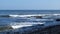 Waves rolling into shore on a rocky coastline in Southern California