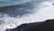 Waves run onto the beach. White foam from the waves on the background of a black beach. Surf on the ocean