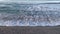 Waves of salty sea water on the beach at sea with splashes