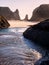 Waves on sandy beach with rock stacks