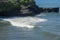 Waves at sea approach the shore and turn into sea foam. The photo of waves is approaching the rock and shore. Indian Ocean waters