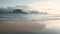 Waves slowly washing a sand beach called haukland. very calm atmosphere during sunset with snowy landscape and mountains in backgr