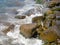 Waves with splashes fall on large stones. Shore view. Beautiful stones that strengthen the shore from the surf. Powerful coastline